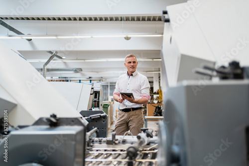 Businessman using a tablet in a factory