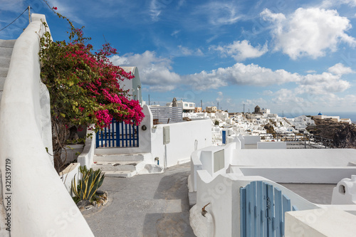 small traditional white houses with a view of the Caldera, the symbol of the island of Santorini in Greece, a view of the island's capital Fira and villages nearby
