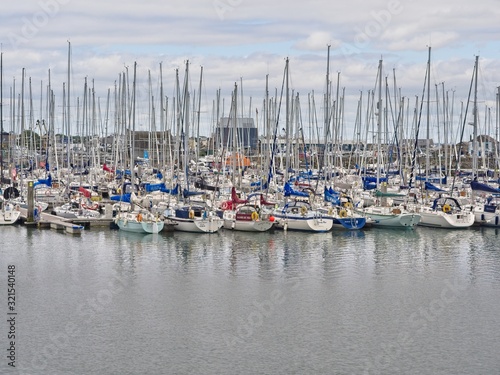 Large amount of sailboats densely packed at the marina of Howth (Ireland) near Dublin on an overcast summer day