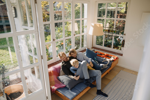 Family using cell phone in sunroom at home photo