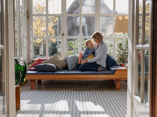 Happy mother and son in sunroom at home