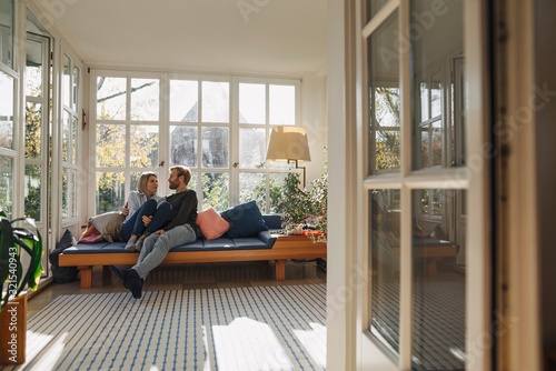 Affectionate couple relaxing in sunroom at home photo