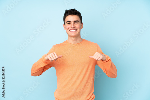 Obraz na plátně Teenager caucasian handsome man isolated on purple background proud and self-sat