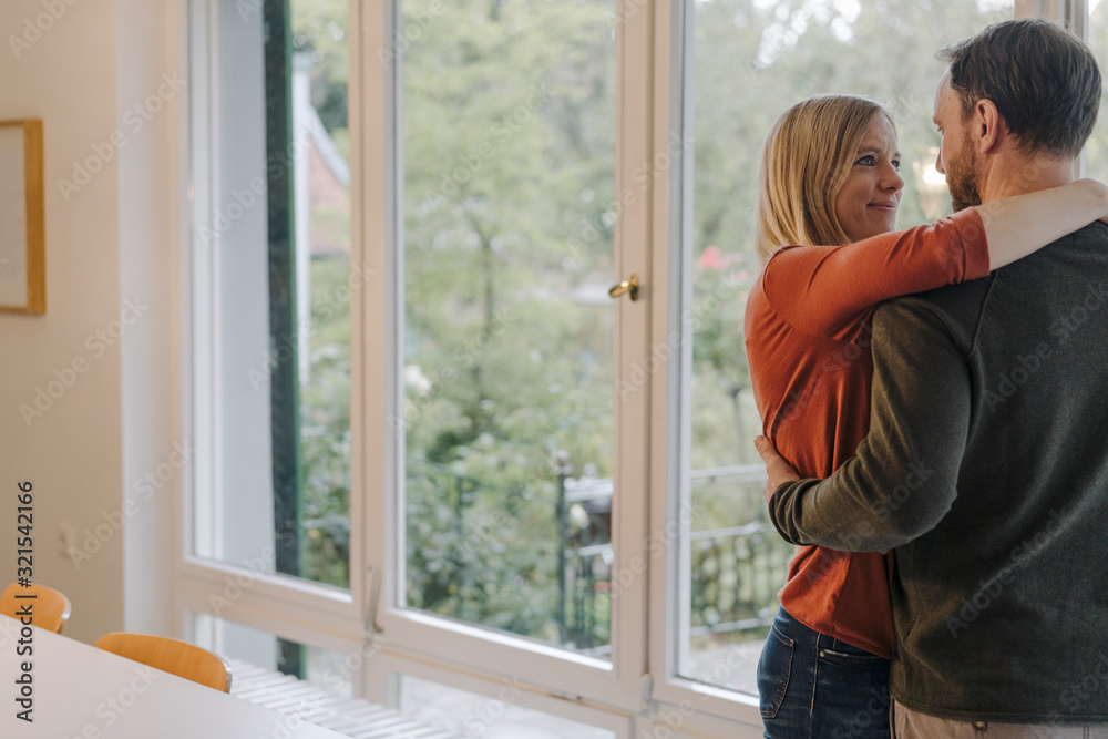 Happy couple embracing in their comfortable home Happy couple embracing in their comfortable home
