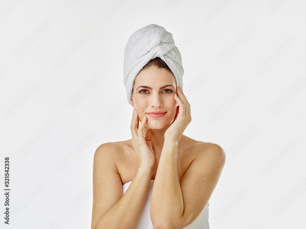 Portrait of smiling woman with hairs wrapped in towel against white background Portrait of smiling woman with hairs wrapped in towel against white background