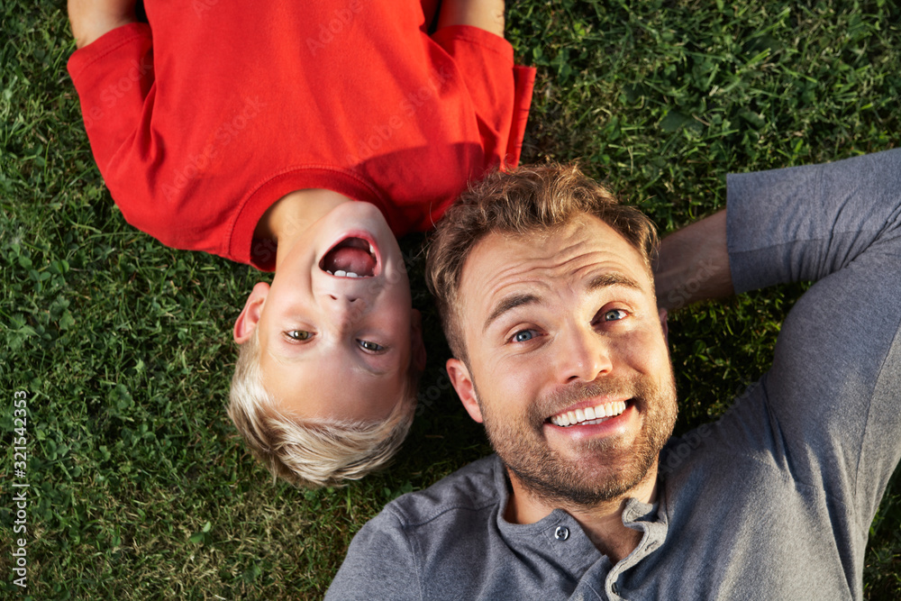Germany, Cologne, Father and son lying in meadow Germany, Cologne, Father and son lying in meadow
