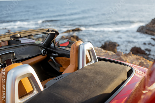 Convertible car on the rocky seaside, no people. Travel by car concept © rh2010