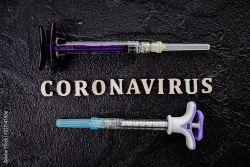 Coronavirus vaccine vial with injection syringe isolated on black background