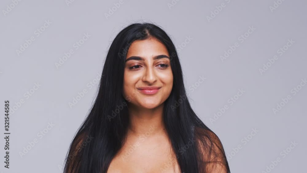 Head And Shoulders Studio Shot Of Calm Woman Smiling At Camera In Slow Motion Head And Shoulders Studio Shot Of Calm Woman Smiling At Camera In Slow Motion