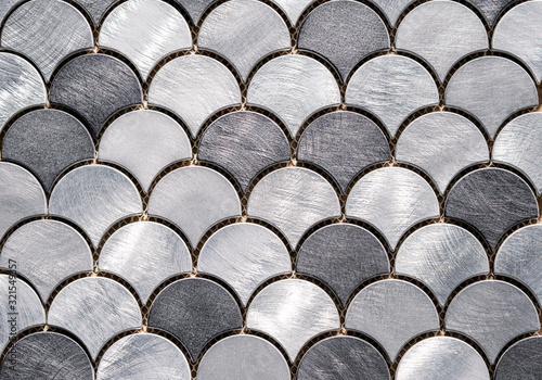 Metal mosaic tile in the form of scales. Silvery tile texture with marine design.