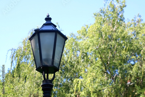 Vintage lamp in park in Zagreb, Croatia. Selective focus, green bokeh.