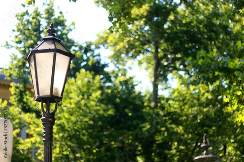 Vintage lamp in park in Zagreb, Croatia. Selective focus, green bokeh.