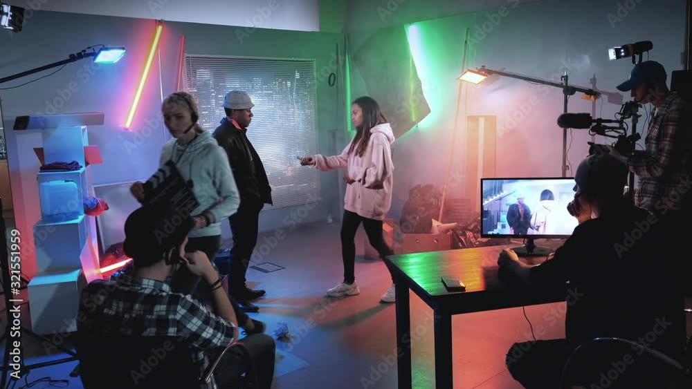 Backstage of film shooting: producer assistant gives action with movie clapper board and the crew starting working. Film shooting in a big film studio.