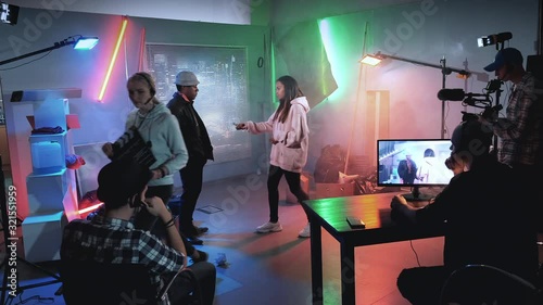 Backstage of film shooting: producer assistant gives action with movie clapper board and the crew starting working. Film shooting in a big film studio.