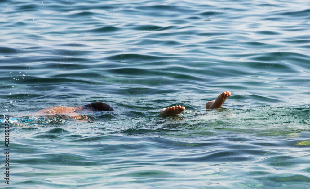 Fototapeta premium One's leg fingers peeking from the sea