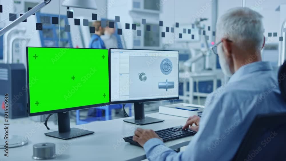 Senior Heavy Industry Engineer Working on Personal Computer, One is Green Mock-up Screen, Second Shows CAD Software with 3D Component. Industrial Factory with High-Tech CNC Machinery Senior Heavy Industry Engineer Working on Personal Computer, One is Green Mock-up Screen, Second Shows CAD Software with 3D Component. Industrial Factory with High-Tech CNC Machinery