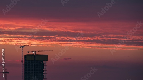 Construction site and crane silhouette with red color sunset.
