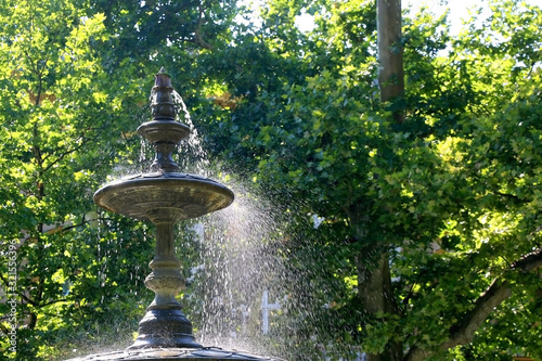 Fountain in the park Zrinjevac, in Zagreb, Croatia. Selective focus, green bokeh.