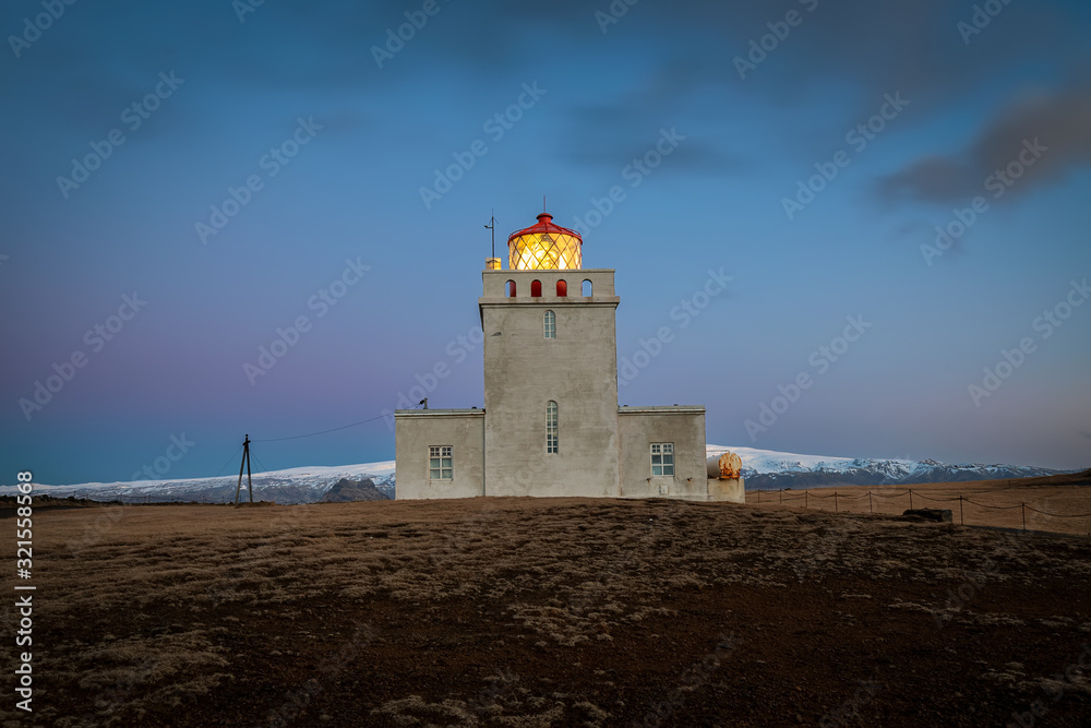 Dyrholaey lighthouse over black sand beach in Iceland