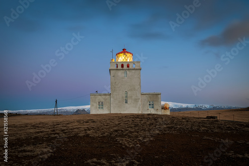 Dyrholaey lighthouse over black sand beach in Iceland