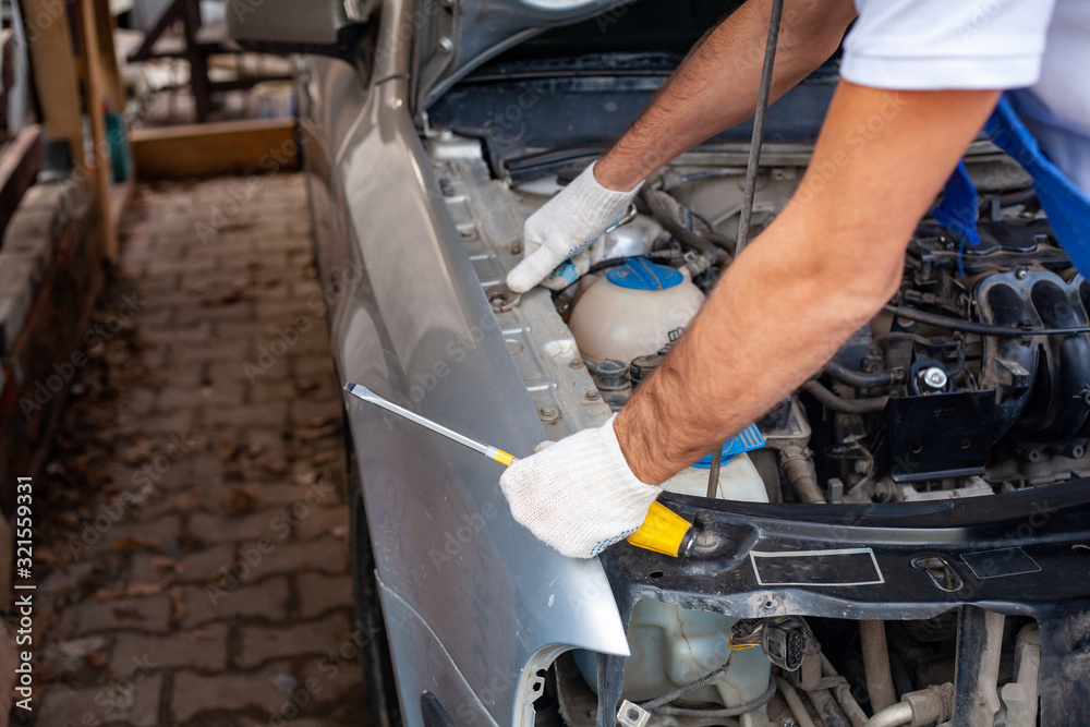 mechanic men with wrench repairing car engine at mechanic men with wrench repairing car engine at