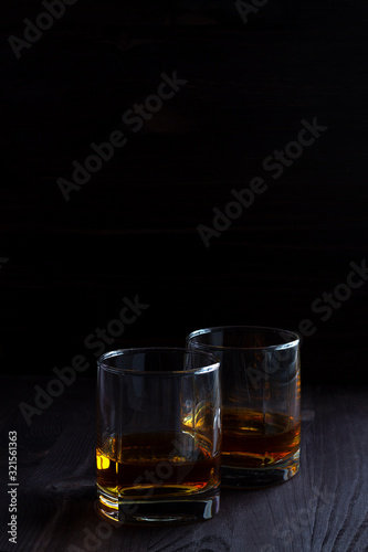 glass of whiskey and ice on wooden table