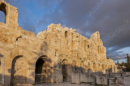 Picturesque view of Greek ruins of Odeon of Herodes Atticus (161AD) - stone Roman theater at the Acropolis hill on sunset. Athens, Greece.