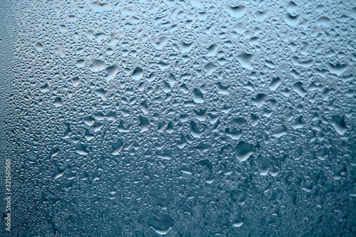 Close Up detail of moisture condensation problems, water drops, texture colorful water drop. Hot water vapor condensed on the cold window glass