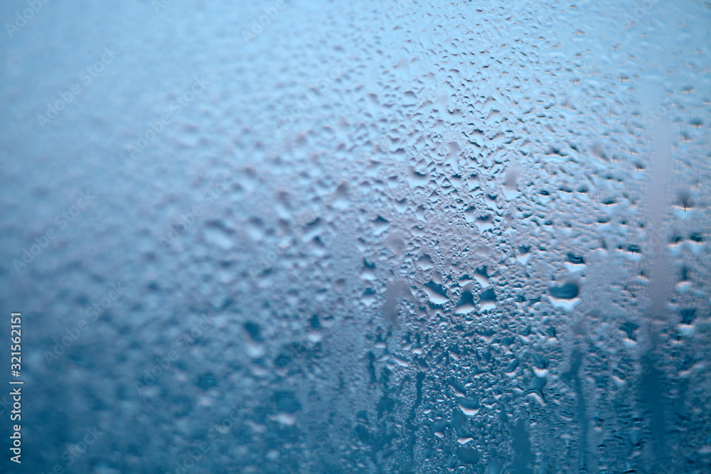 Close Up detail of moisture condensation problems, water drops, texture colorful water drop. Hot water vapor condensed on the cold window glass