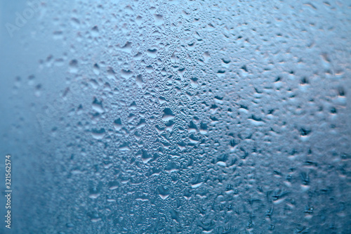 Drops of condensed steam, water drops. Close up detail of moisture condensation problems. Hot water vapor condensed on the cold window glass