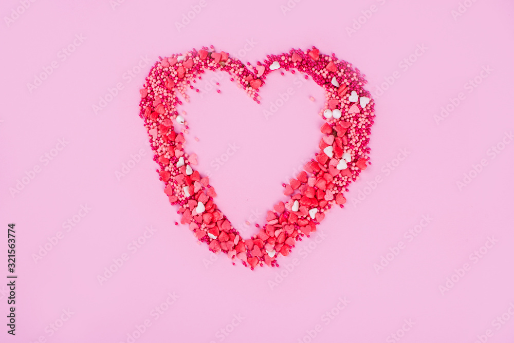 A big heart of little sweet hearts on a pink background.