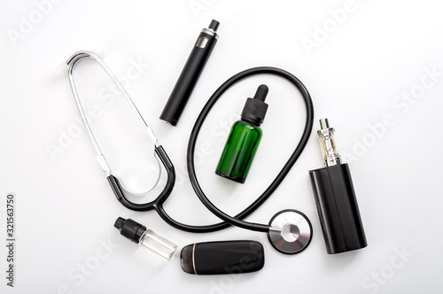 Help to stop smoking cigarettes and health risk linked to vaping concept with stethoscope, e cigarette, ejuice and vape pod isolated on white background