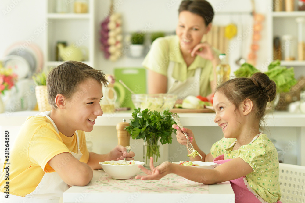 Cute brother and sister eating together in kitchen Cute brother and sister eating together in kitchen