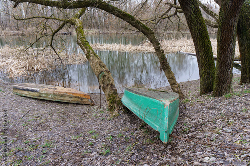 Two old fishing boats lie on the river bank. photo