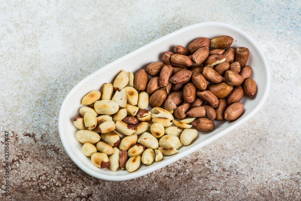 Peanuts in a white cup an old wooden floor. ramadan food. healthy nutrition. healthy food. vegetarian snack Peanuts in a white cup an old wooden floor. ramadan food. healthy nutrition. healthy food. vegetarian snack