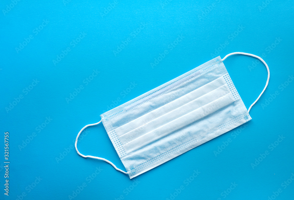Surgical protective mask on a blue background. Blue medical mask for protection against influenza, coronavirus and other viruses. Surgical protective mask on a blue background. Blue medical mask for protection against influenza, coronavirus and other viruses.