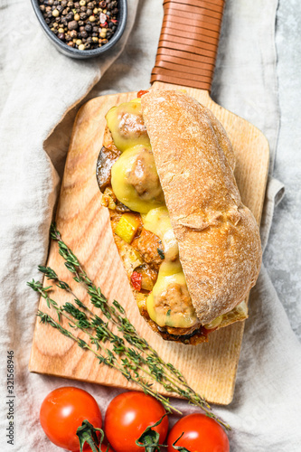 ciabatta sandwich with meatballs, cheese and tomato sauce. Gray background. Top view