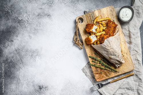 Fish and chips, French fries and cod fillet fried in breadcrumbs. Gray background. Top view. Copy space