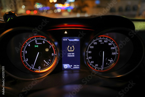 Warning lights flash on the car dashboard. Low tire pressure error sign. 