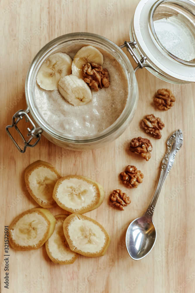 Yogurt in a glass bowl with sliced banana and walnut. Healthy food in the morning. Yogurt in a glass bowl with sliced banana and walnut. Healthy food in the morning.