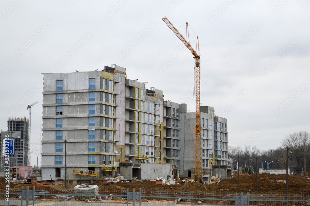 Construction of a new microdistrict with high houses, new buildings with developed infrastructure with the help of large industrial cranes and professional construction equipment in a big city Construction of a new microdistrict with high houses, new buildings with developed infrastructure with the help of large industrial cranes and professional construction equipment in a big city