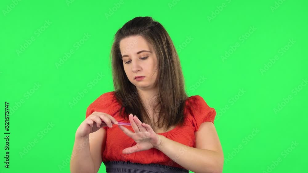 Portrait of cute girl making herself manicure with pink nail file. Green screen Portrait of cute girl making herself manicure with pink nail file. Green screen