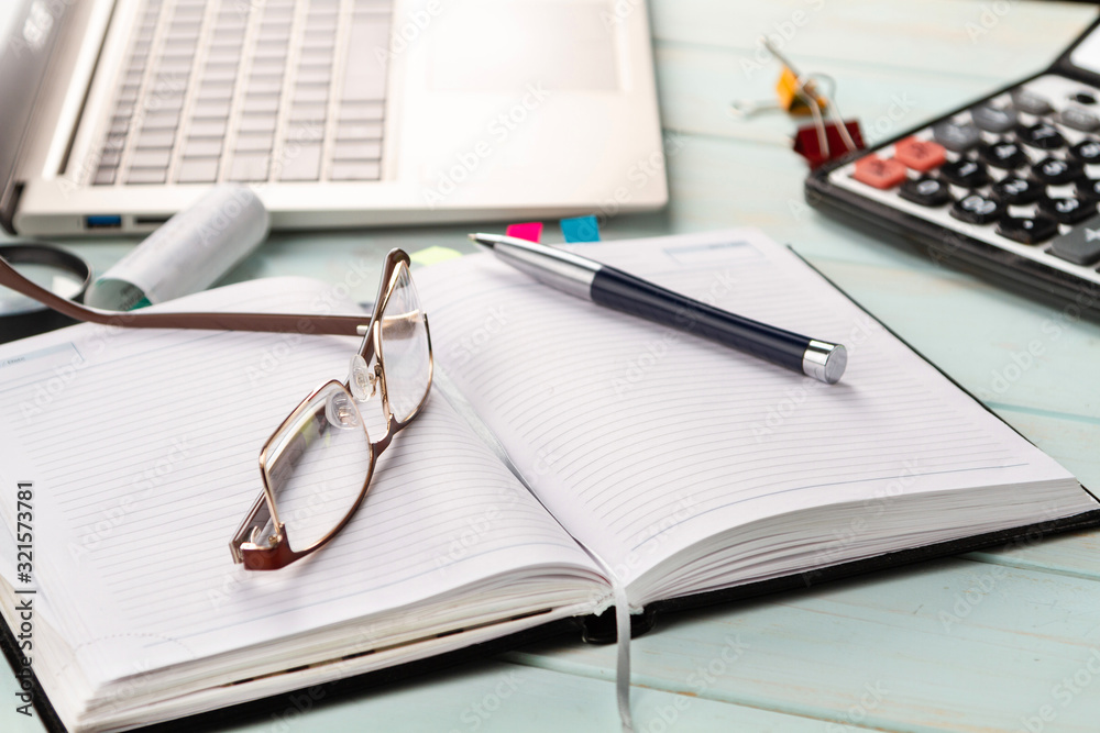 Notebook, pen, glasses, financial documents on the table. Notebook, pen, glasses, financial documents on the table.
