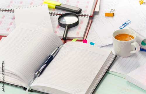 Work with documents. Notebook, pen, notebook, calculator, financial documents, a cup of cappuccino coffee on the table.