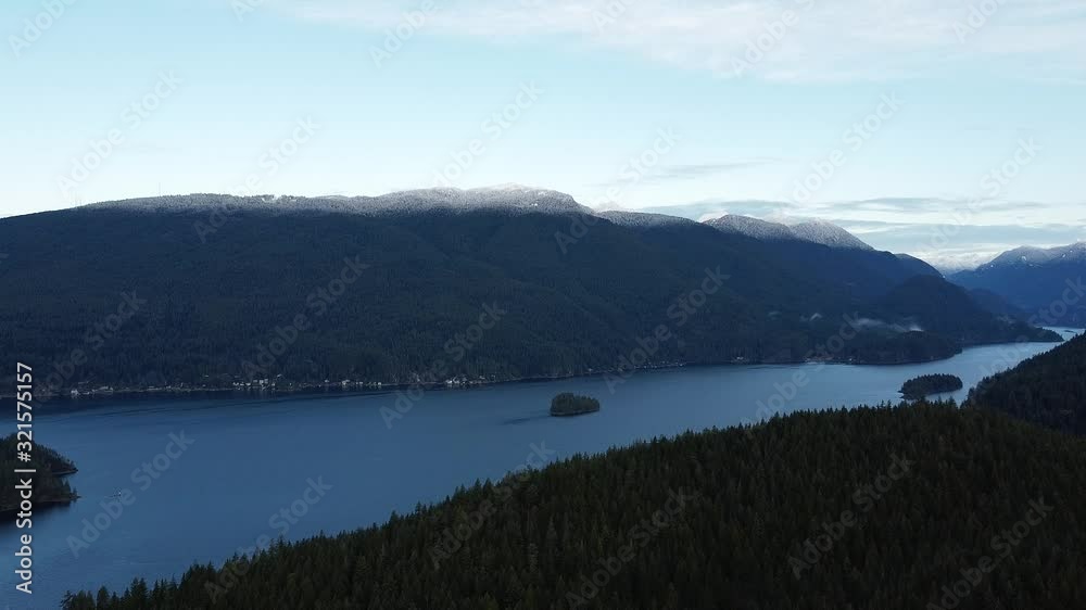 River with a small island in the center and mountains covered with the snow behind River with a small island in the center and mountains covered with the snow behind