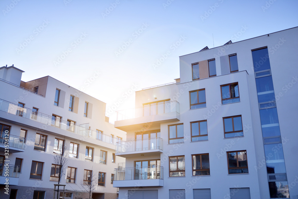 Sun rays light effects on urban buildings. Fragment of modern residential apartment with flat buildings exterior. Detail of new luxury house and home complex. 