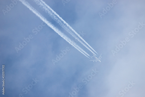 Bottom view of a completely white airplane, an unrecognized commercial airlin