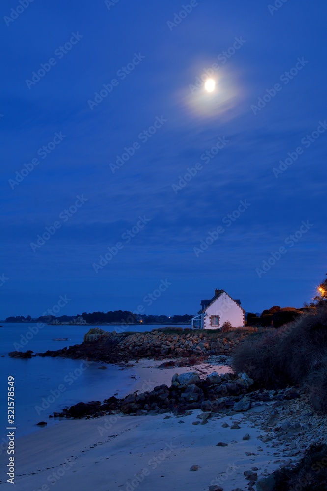 The moon over an house in the night in brittany. France