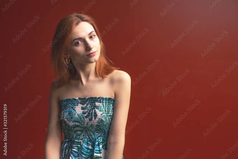 Red-haired girl on a red background shows different emotions Red-haired girl on a red background shows different emotions