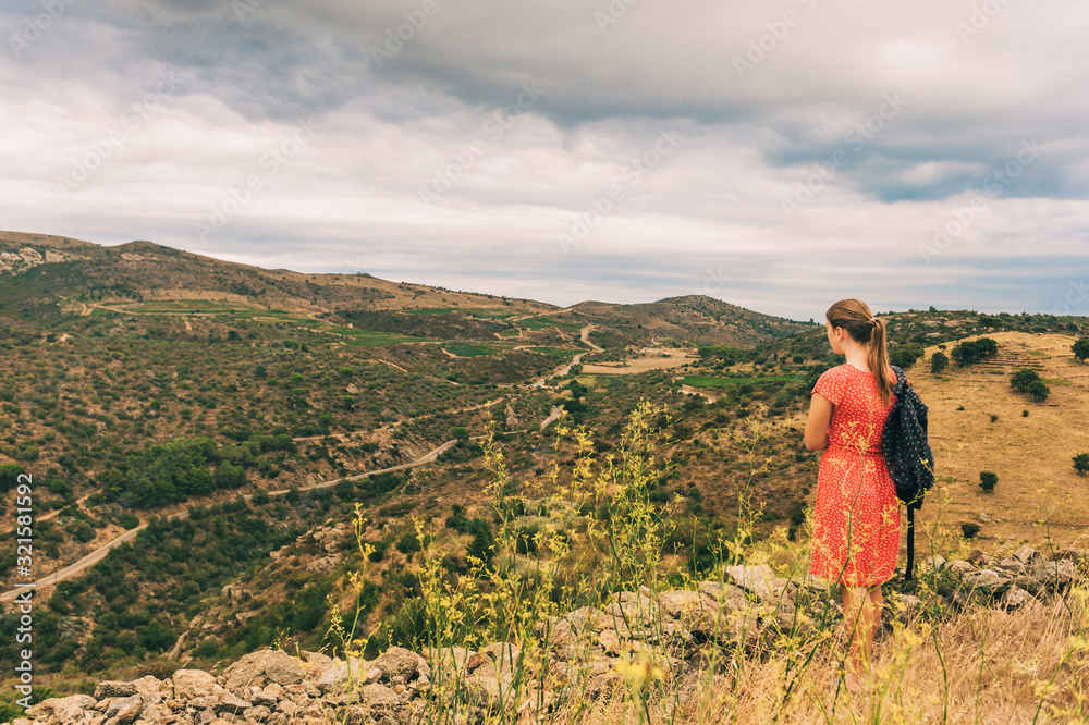 Naklejka premium Young girl tourist admiring landscape of Cap de Creus, National Park on the Costa Brava, Spain